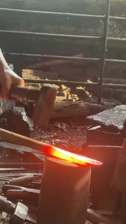 Thanh thép nung nóng trên đe trong xưởng rèn